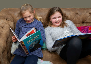 Chillen met een boek op de bank bij buitenschoolse opvang - Up Kinderopvang aan de Van Alkemadestraat in Delft