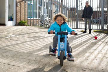 Fietsend over het plein rijden bij kinderdagverblijf - Up Kinderopvang aan de Daniël Catterwijckstraat in Rijswijk