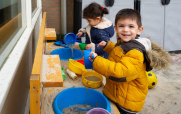 Spelen met zand buiten bij peuteropvang - Up Kinderopvang aan de Henri Dunantlaan in Rijswijk