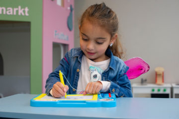 Tekenen op een wisbord bij peuteropvang - Up Kinderopvang aan Dr Poelslaan in Rijswijk