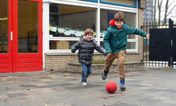 Voetballen op het plein bij buitenschoolse opvang - Up Kinderopvang aan de Wiardi Beckmanlaan in Rijswijk