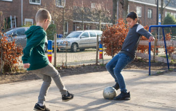 Voetballen op het plein bij buitenschoolse opvang - Up Kinderopvang aan de Willem van Rijswijckstraat in Rijswijk